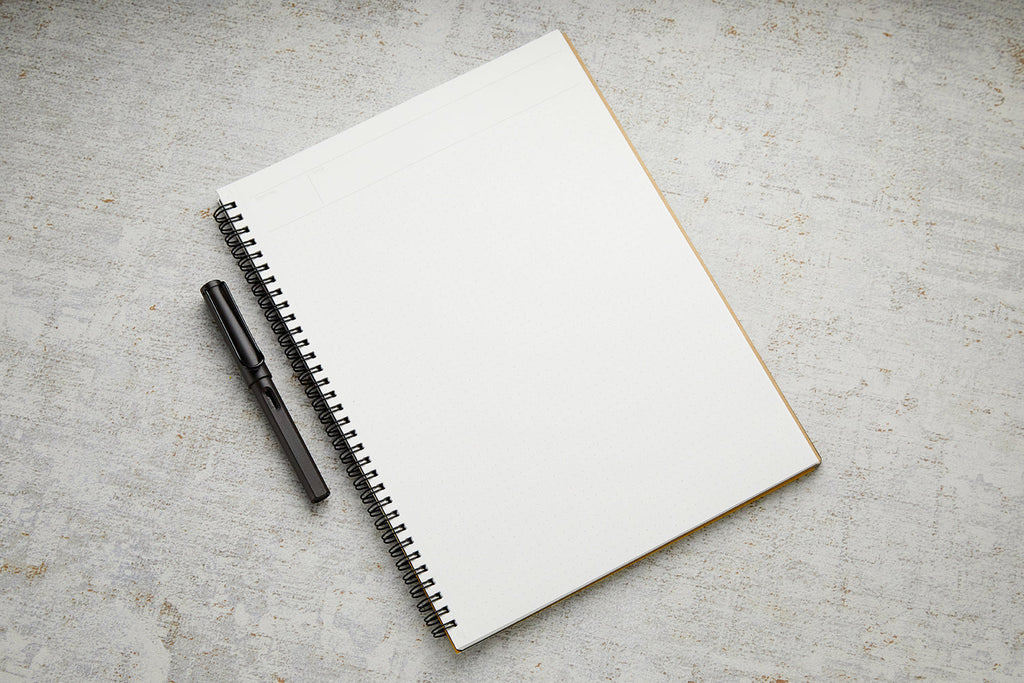 Open Maruman Mnemosyne A4 Planner Notebook with pen placed on blank dot grid pages.