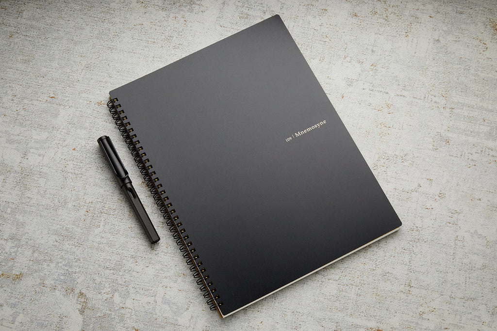 Black cover Maruman Mnemosyne A4 Planner Notebook with pen resting on top.