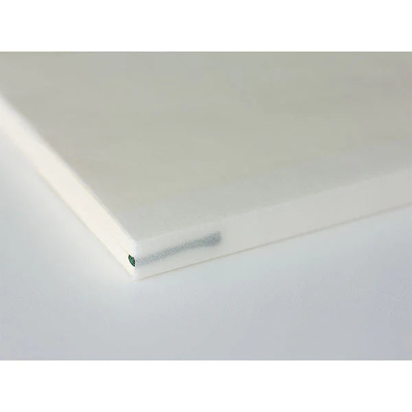 Detailed view of Midori MD Paper Notebook A6 Ruled, smooth ivory paper with thread-stitch binding visible.
