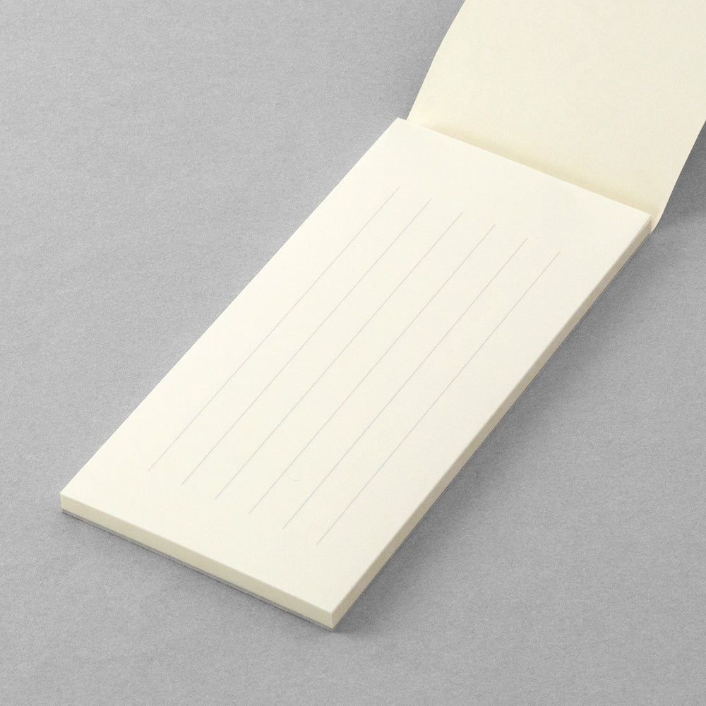 Midori MD Paper One Stroke Note opened with ruled pages visible on a desk.
