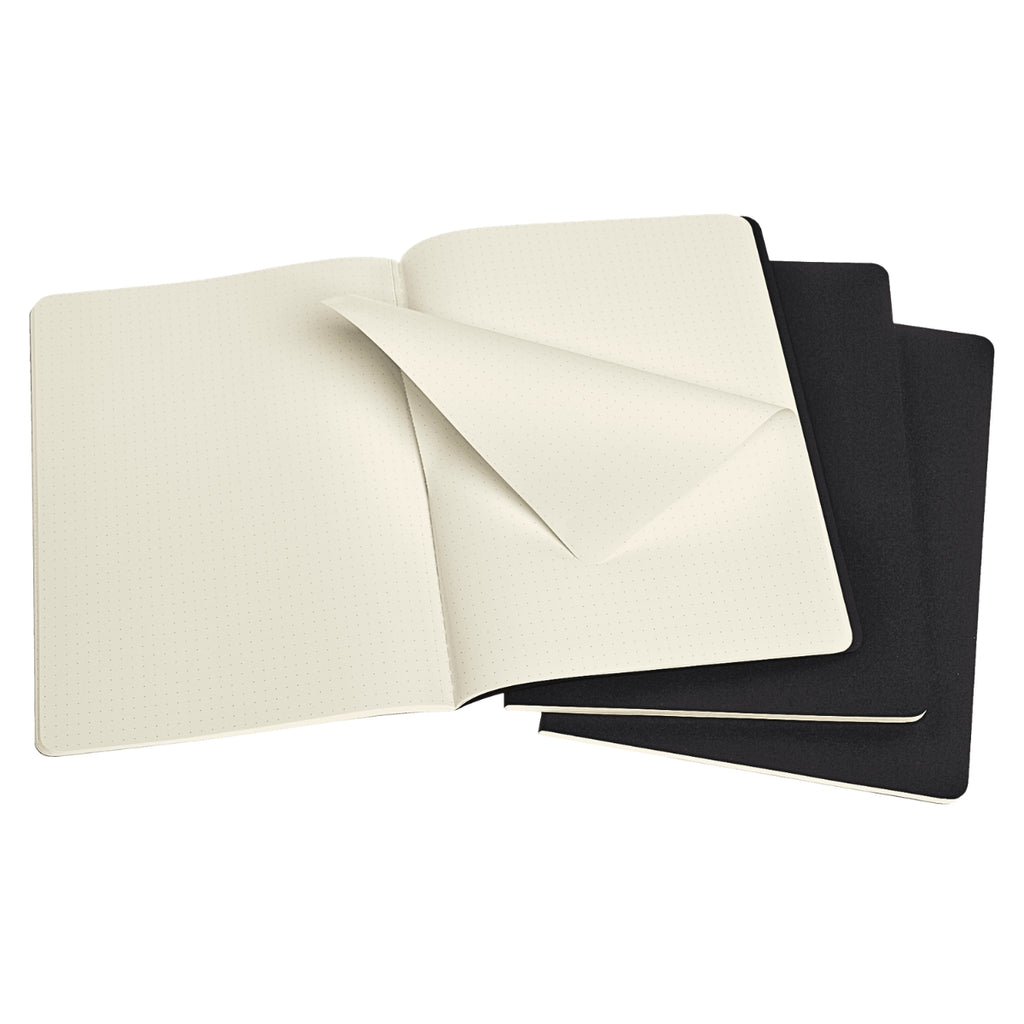 Open Moleskine Extra Large Black Cahier Dotted notebooks showing cream pages and black covers.