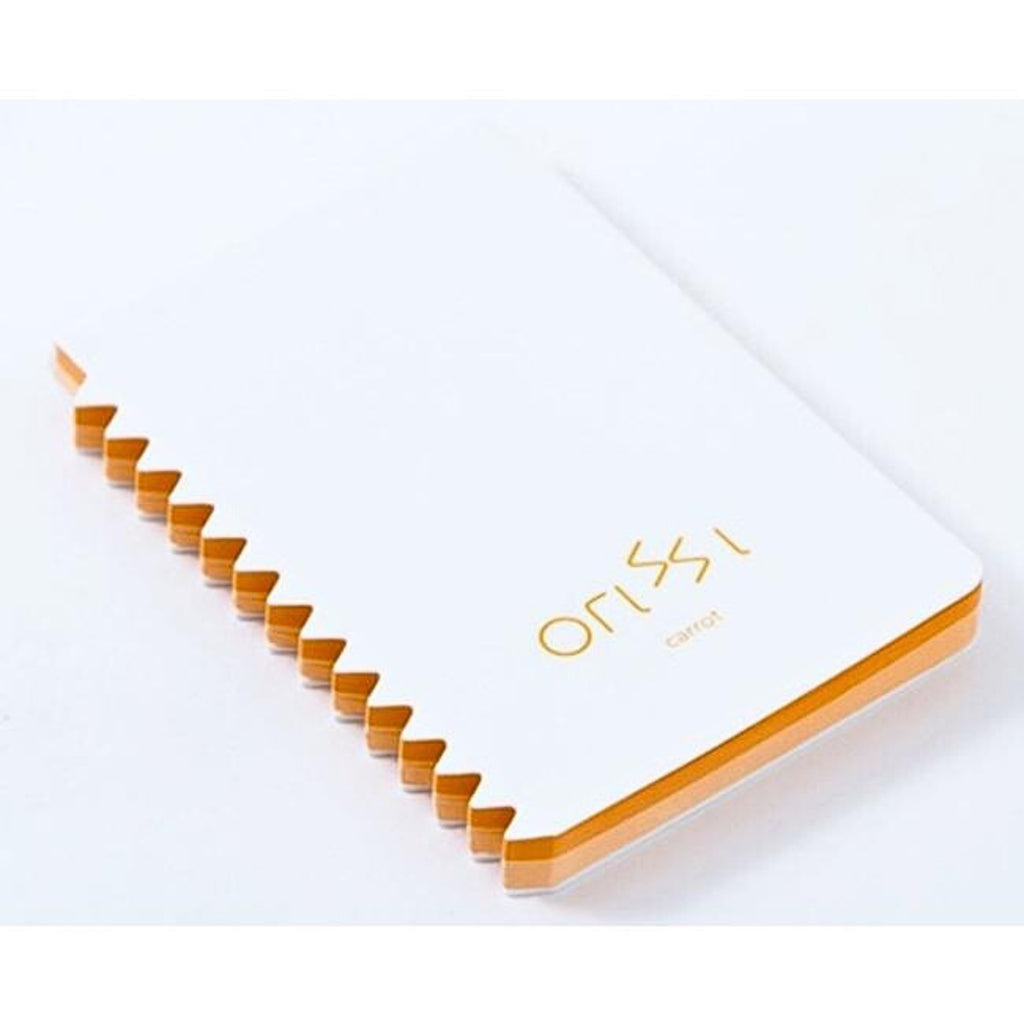 Angled view of Orissi notepad with orange inner pages and zigzag edge, labelled ‘carrot’.