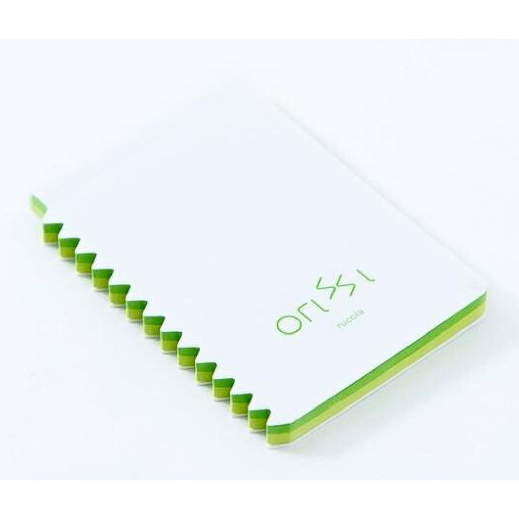 Closed Orissi notepad with green-edged pages and ‘rucola’ label on white cover.