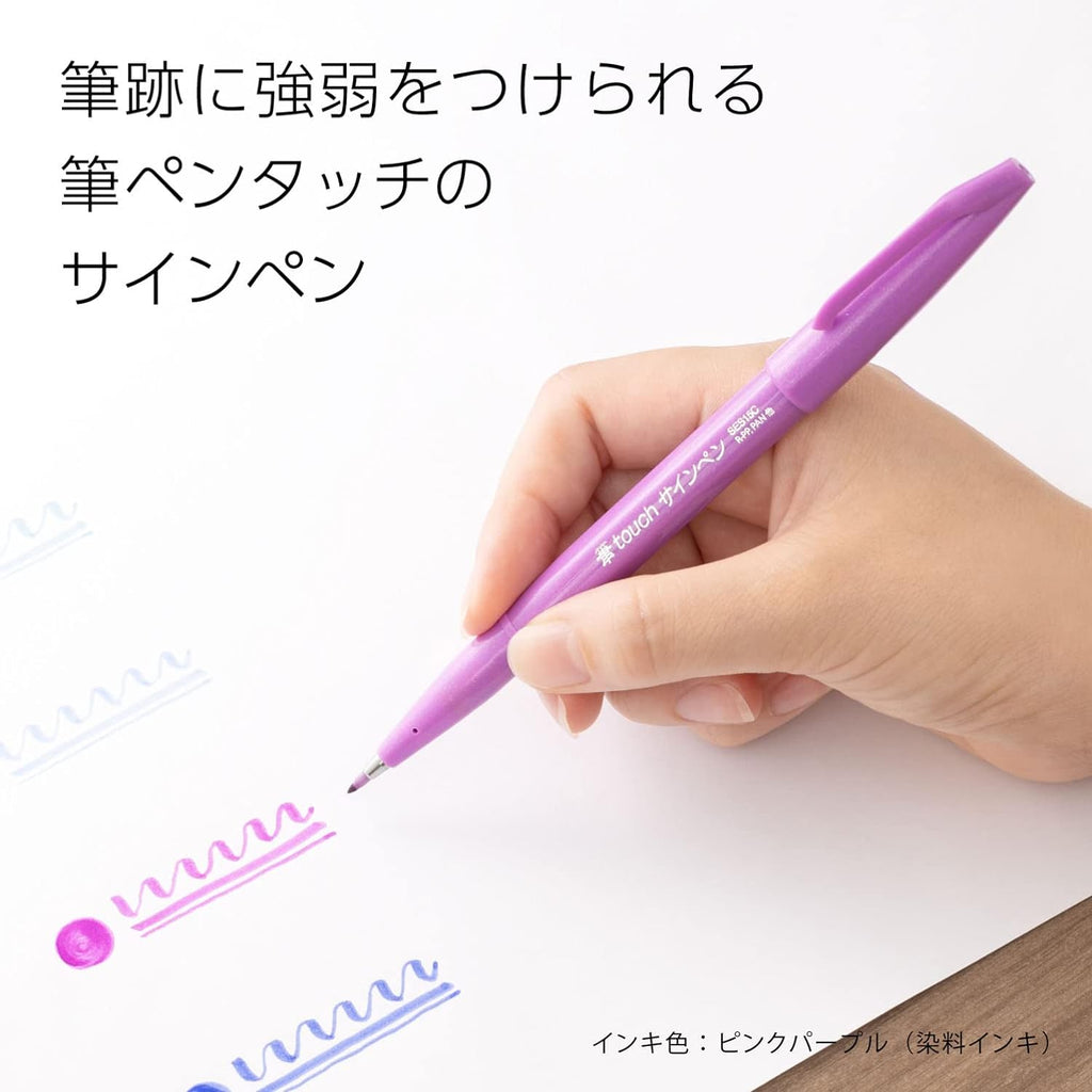 Hand holding a Periwinkle FudeTouch Spectrum Brush Sign Pen, highlighting its sleek design and ease of use.