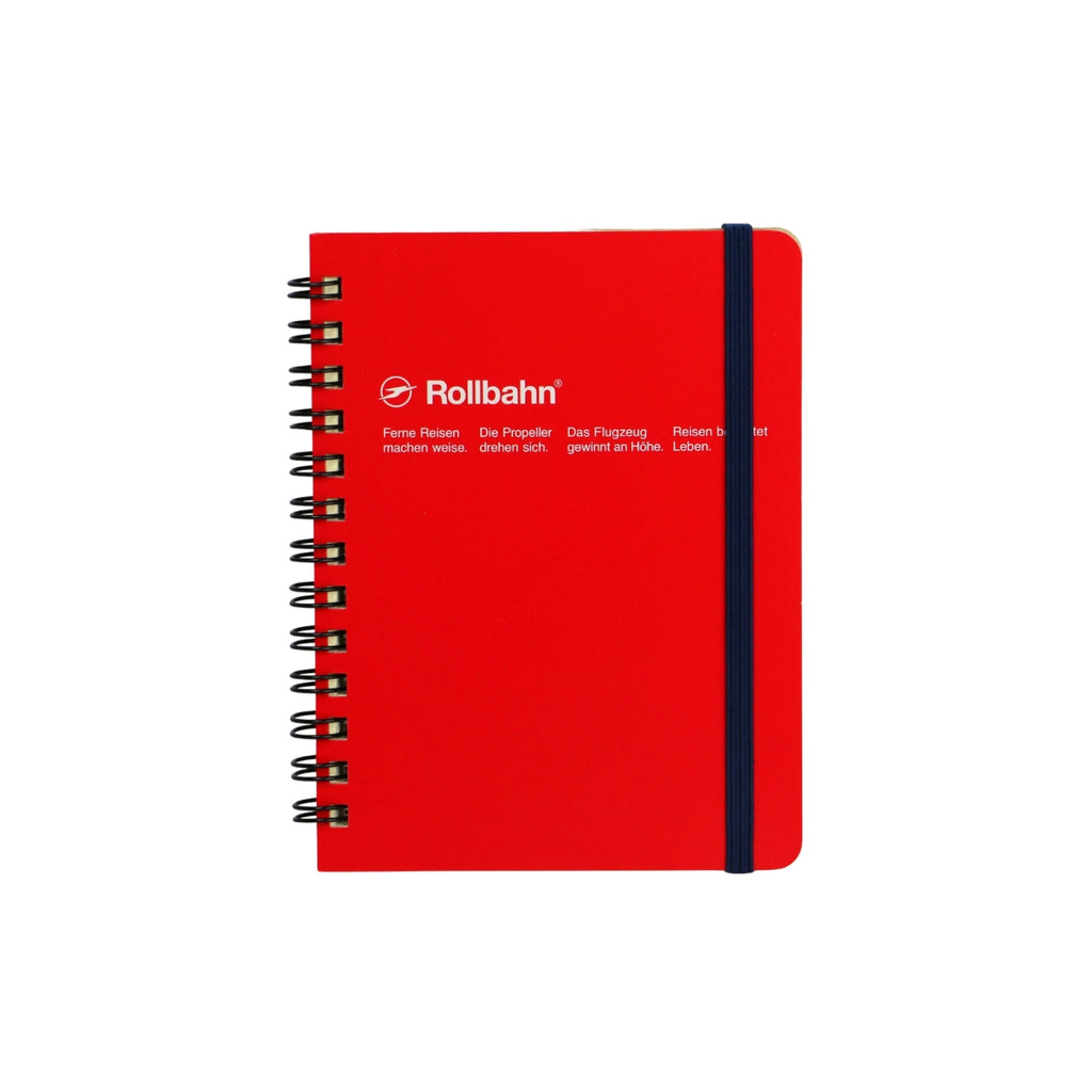 The front cover of a red mini Rollbahn notebook with spiral binding and an elastic band, featuring printed German text in white.