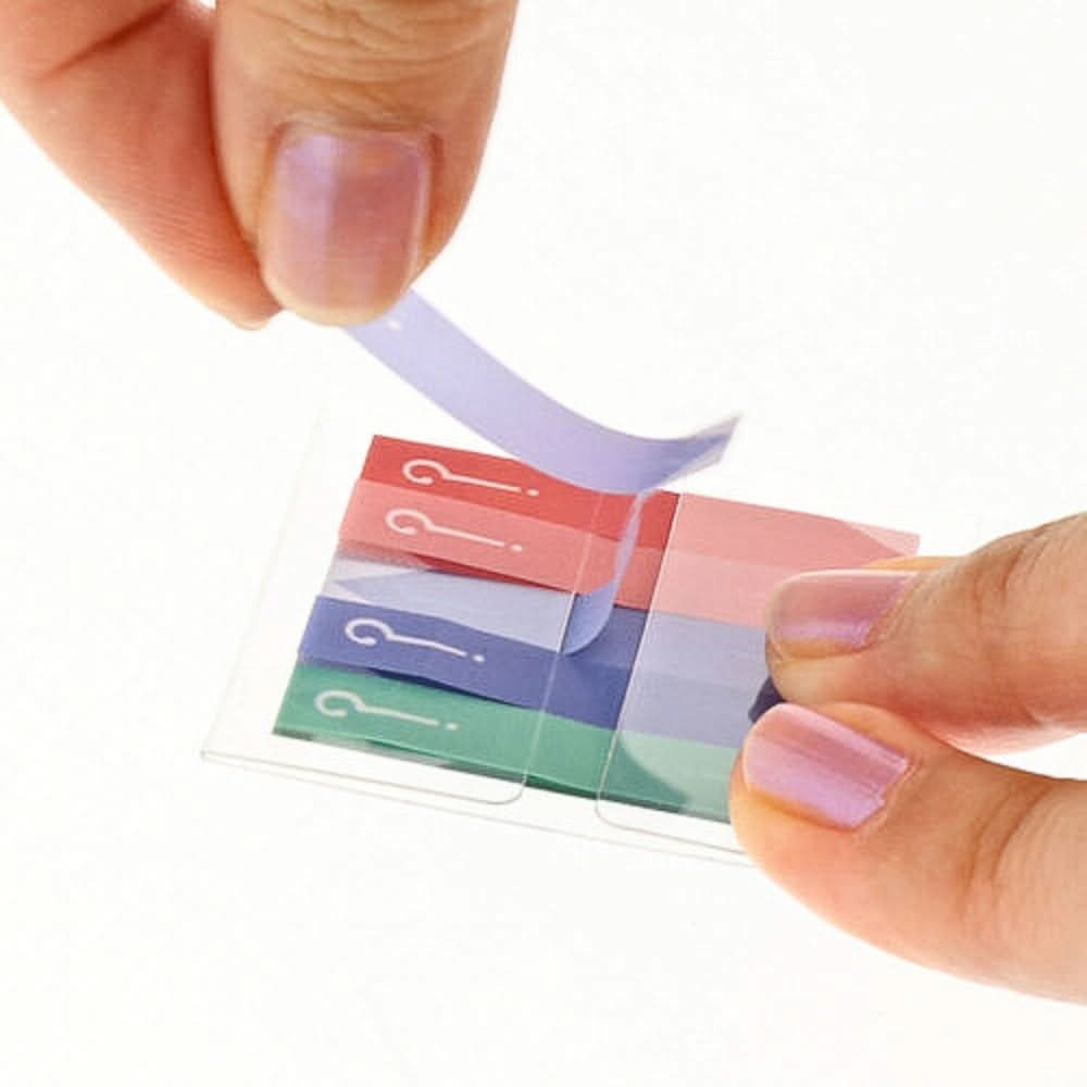 A person peeling off a purple Sun-Star Slim Piri-it Sticky Memo tab with a white question mark design.