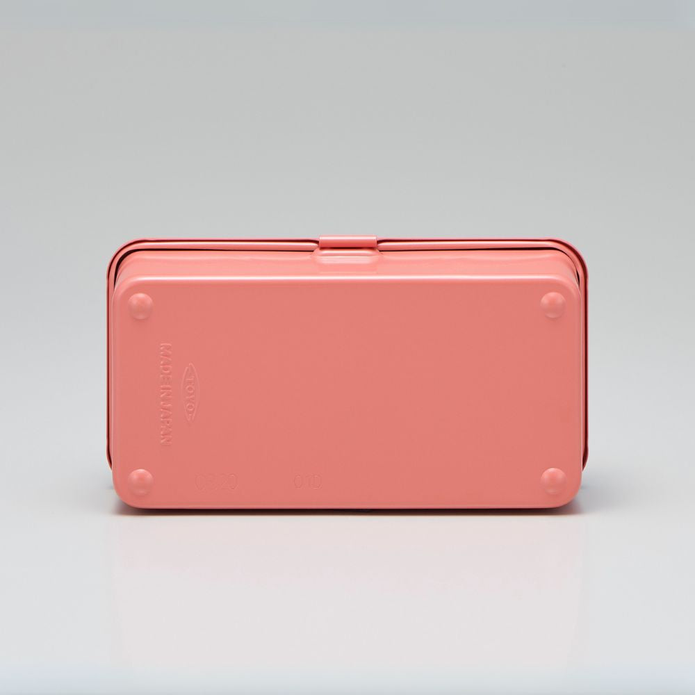 Bottom view of a coral-coloured TOYO STEEL T-190 toolbox showing embossed branding and rivet details.