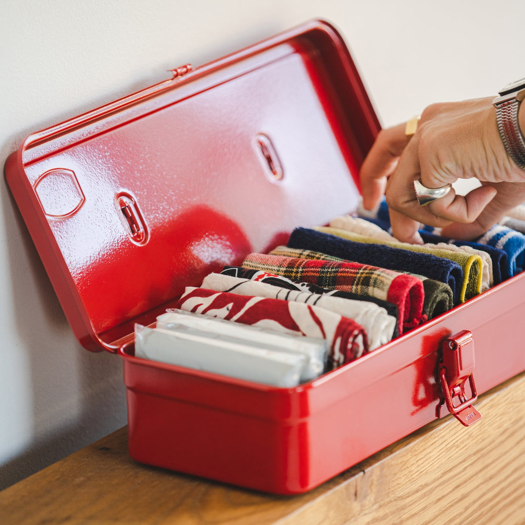 Red TOYO T-320 toolbox open and neatly filled with folded handkerchiefs or fabric items.