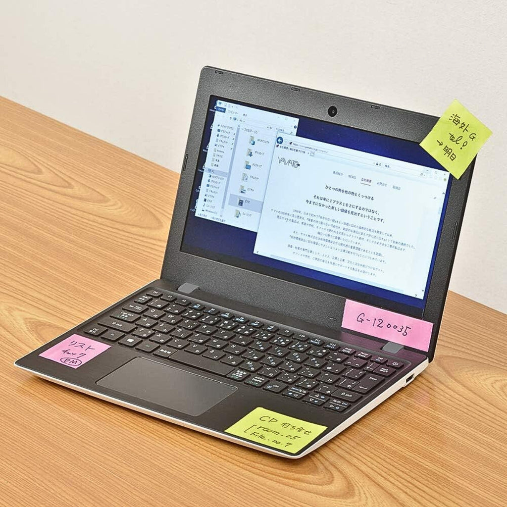Laptop and notepad labelled with coloured tape from the Yamato Double Roll Tape Dispenser.