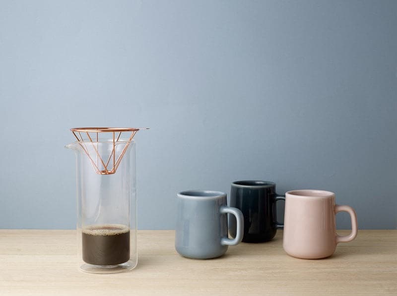 Toast Living H.A.N.D 300ml mugs in assorted colours arranged on a tabletop beside a glass dripper.